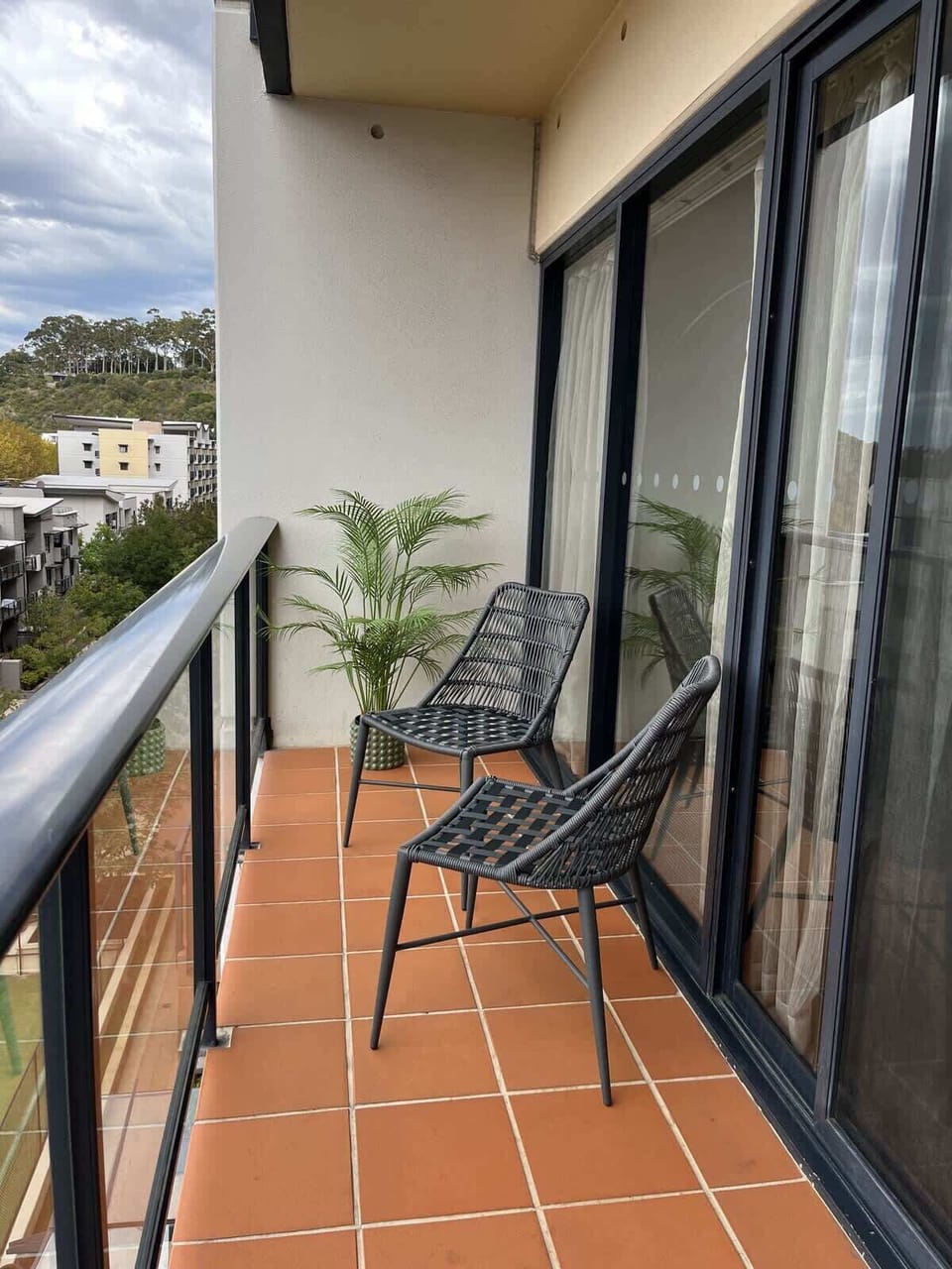 Enjoy your morning coffee or evening drink on your private, covered balcony, featuring comfortable seating for two. It's the perfect spot to relax and take in the fresh air.