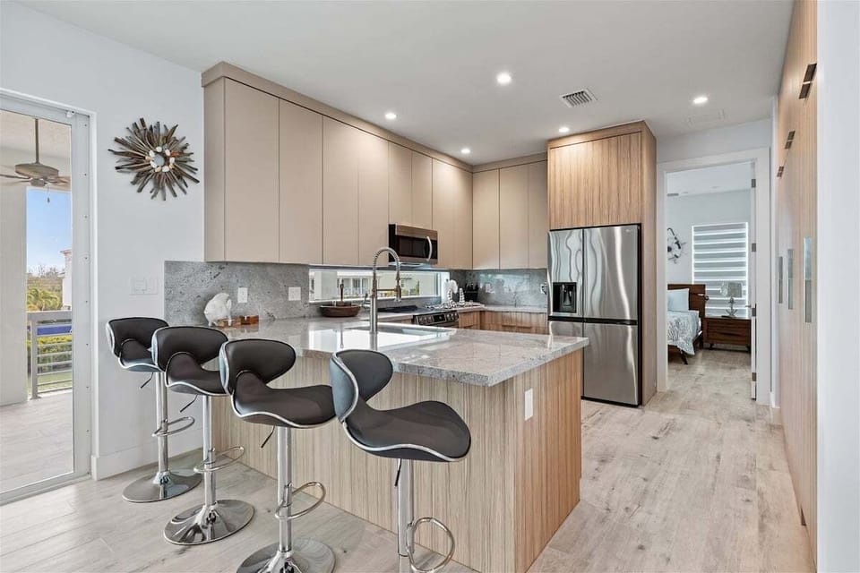Fully equipped chef's kitchen featuring modern appliances and a Keurig coffee maker in a luxury waterfront home.