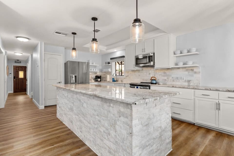 Fully updated kitchen with a large center island, modern appliances, and ample counter space—designed for cooking, entertaining, and group meals with ease.