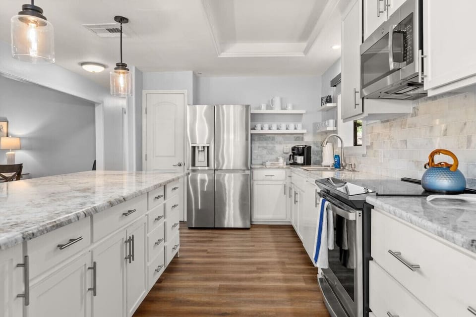 Fully updated kitchen with a large center island, modern appliances, and ample counter space—designed for cooking, entertaining, and group meals with ease.