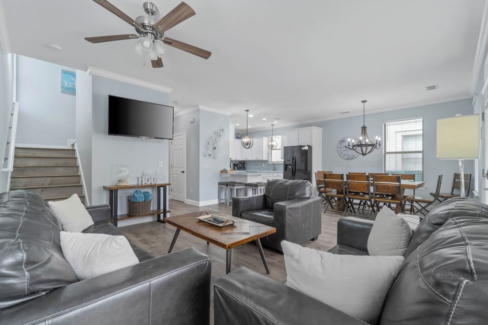 Large living room with TV; dining room and kitchen in background