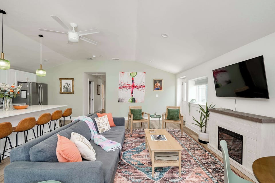 Living area with game table, open concept to kitchen and large entertainers island with backyard access. 