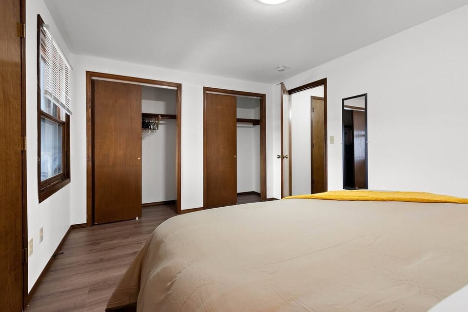 Spacious bedroom features king bed, full length mirror, and ample closet space.