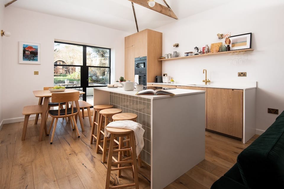 East Lodge Home Farm - dining table with bench seating and two chairs as well as stool seating at the central island