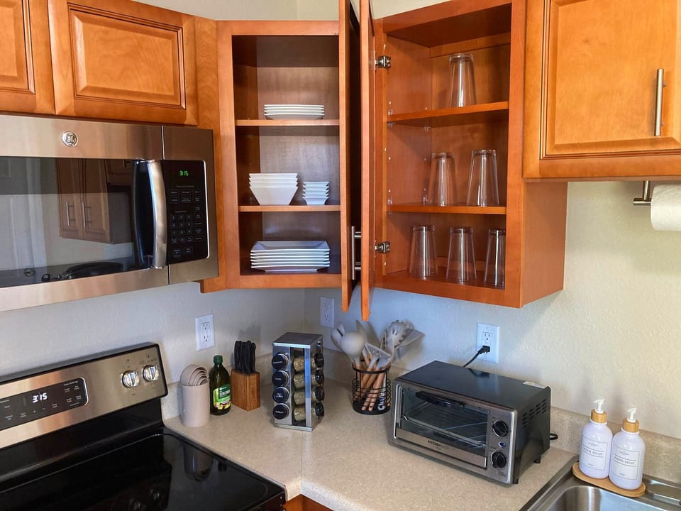 Kitchen is fully stocked with glasses, dishes, and cooking utensils