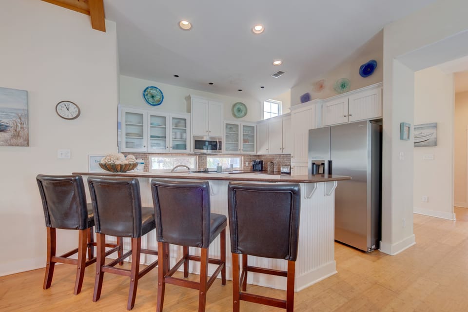 Your gourmet kitchen invites morning coffee at the breakfast bar, with coastal accents and gleaming appliances ready for culinary adventures.
