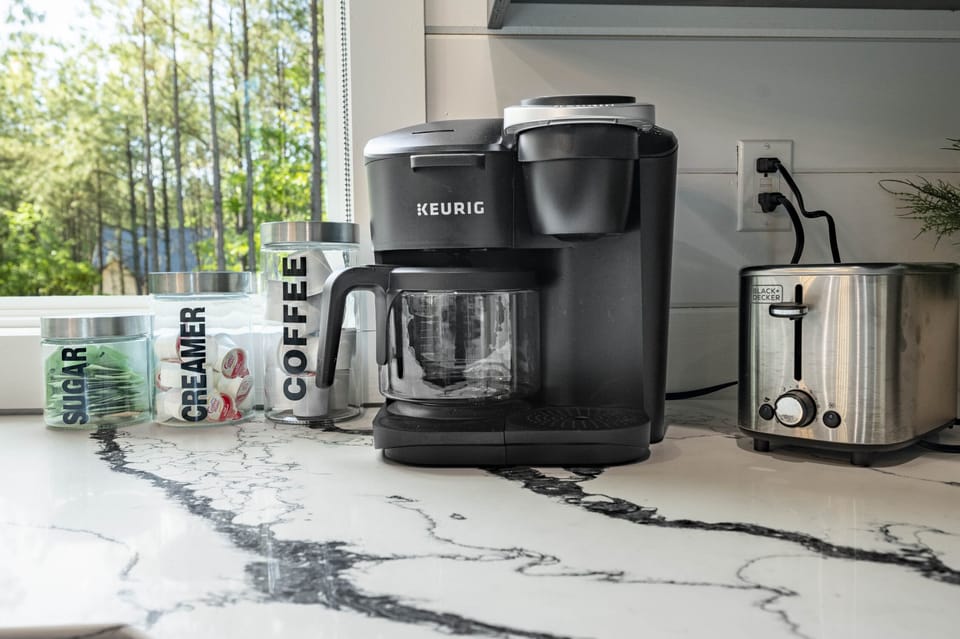 Coffee station with sugar, creamer, and a Keurig maker.