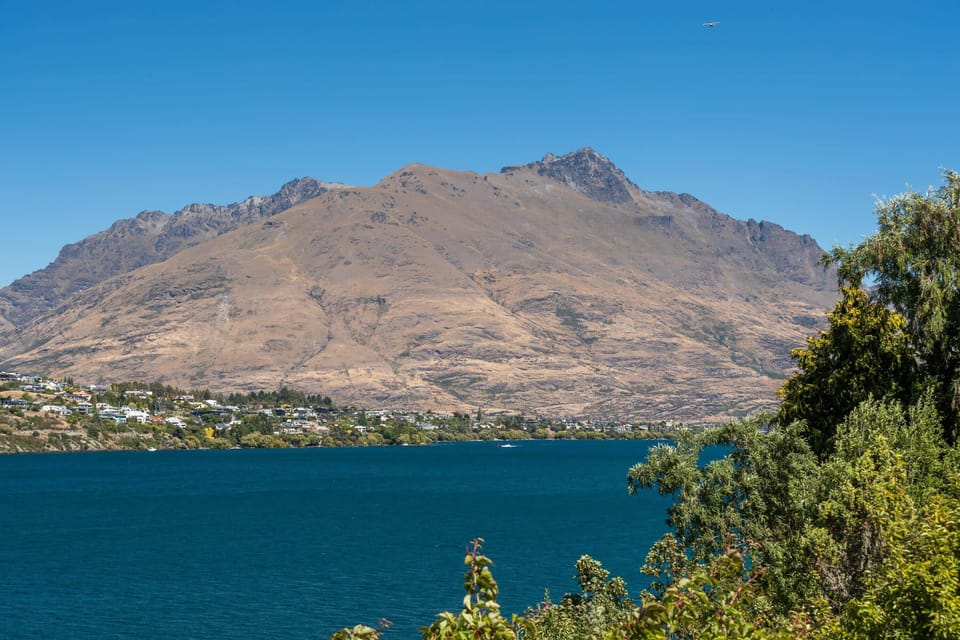 Scenic Vista: Marvel at breathtaking mountain views from lakeside tranquility in Queenstown!