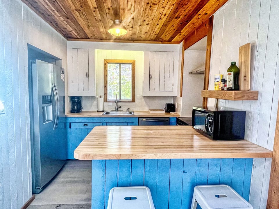 Kitchen w/ dishwasher, oven + stove, full size refrigerator.