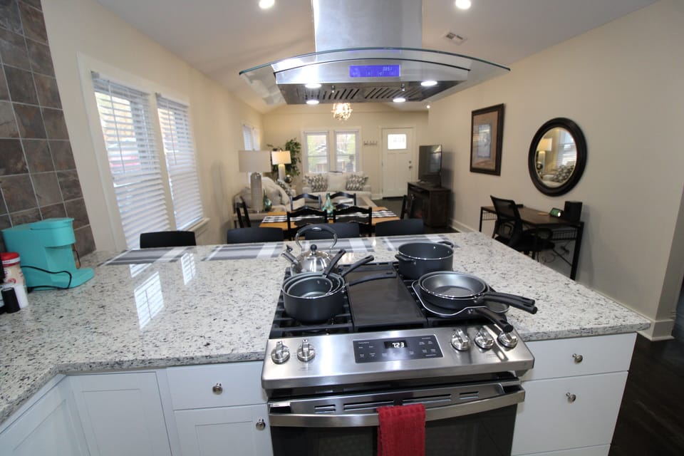 Kitchen has an island with 4 seats and stove with hood.  Full cooking supplies