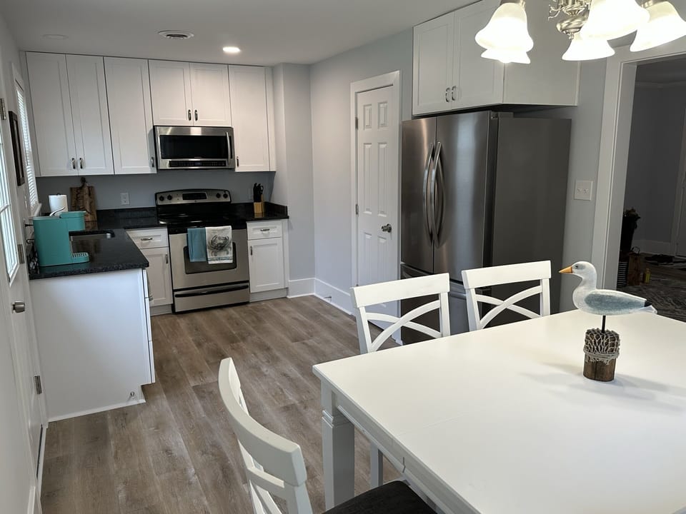 Full kitchen with access to back patio, grill, and outdoor seating. 