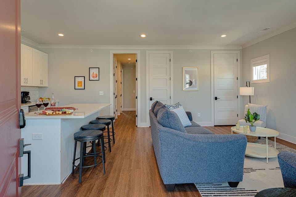 Modern living space featuring designer furnishings and a flat-screen SMART TV overlooking the fully equipped kitchen.