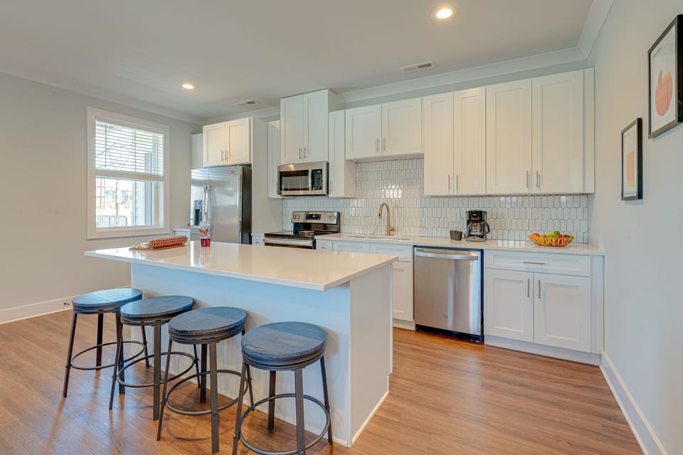 Bright open kitchen stocked with your basic cooking essentials. Complete with stainless steel appliances and breakfast bar seating.