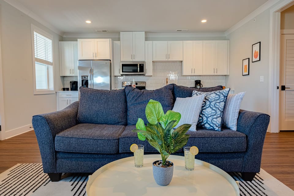 Modern living space featuring designer furnishings and a flat-screen SMART TV overlooking the fully equipped kitchen.