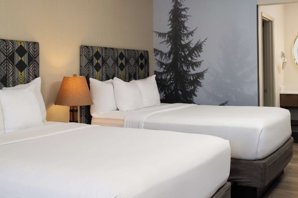 Drift off on pillowy bedding beneath warm bedside lighting.