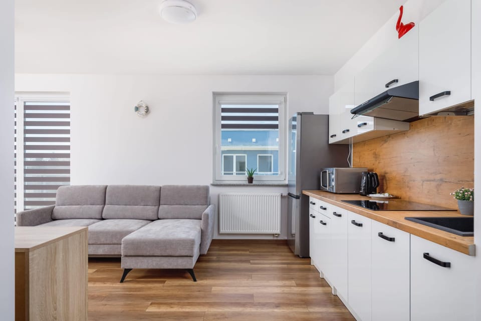  A compact corner of the kitchen showcasing a microwave and kettle on the countertop. Modern design with practicality in mind.