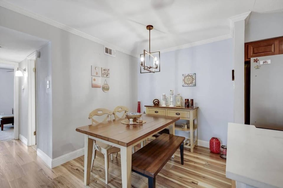This cozy and inviting dining room features a beautiful wooden dining table perfect for gatherings with your favorite people.