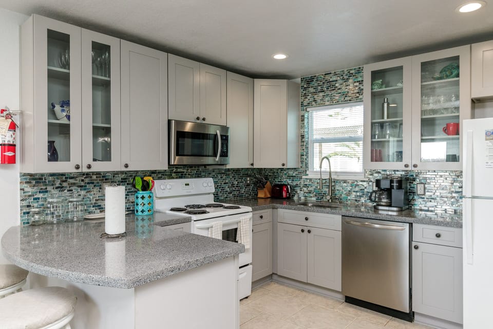Your fully-equipped kitchen features granite counters, glass tile backsplash, and everything you need to prepare delicious meals together.