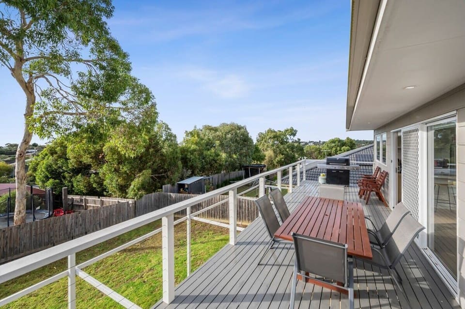 A large east-facing deck overlooks the backyard and captures the leafy views over Jan Juc