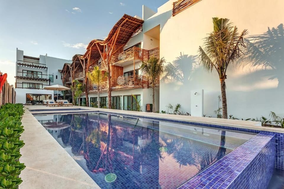 Dive into the sparkling pool beside stylish, sunlit suites.