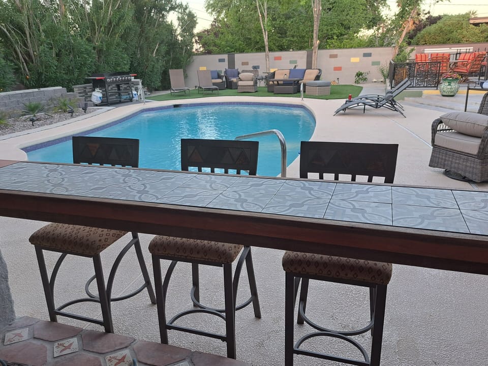 Pergola includes TV, barstools, chairs, treadmill, art, misters