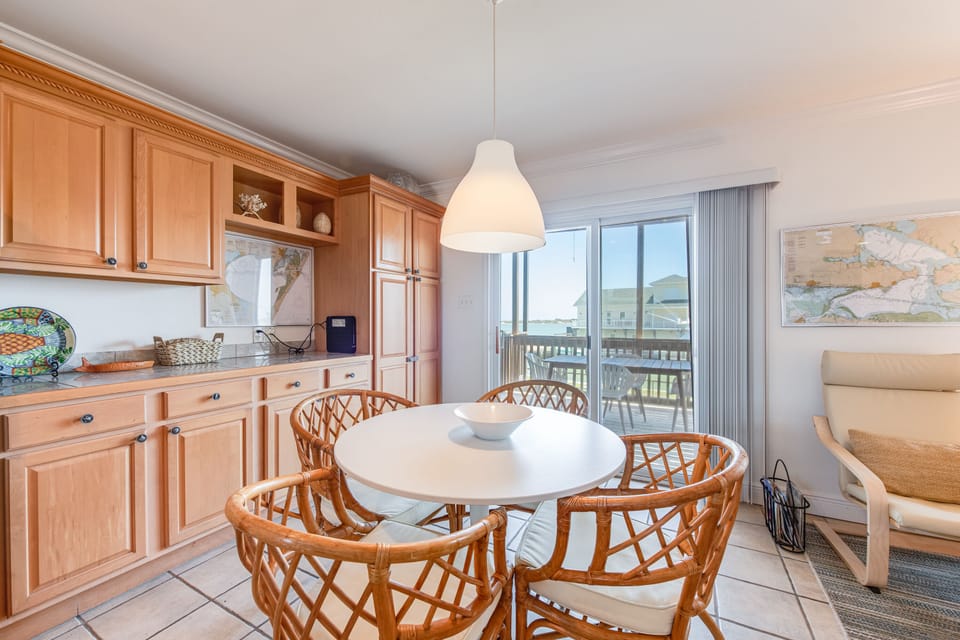 Your bright kitchen flows seamlessly into your dining area, where warm wood tones and coastal views create the perfect setting for memorable meals.