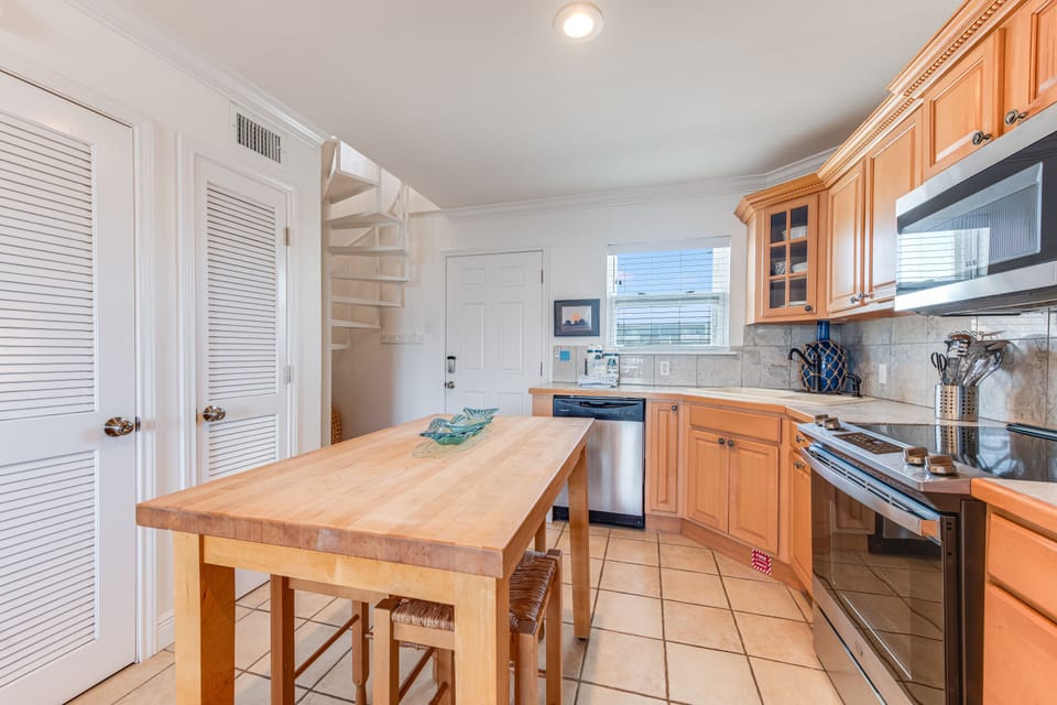 Your fully equipped kitchen features warm wood cabinetry, modern appliances, and a convenient breakfast island for casual dining.