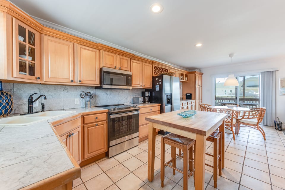 Your spacious kitchen features warm wood cabinets, modern appliances, and a breakfast bar where you'll enjoy morning coffee overlooking the view.