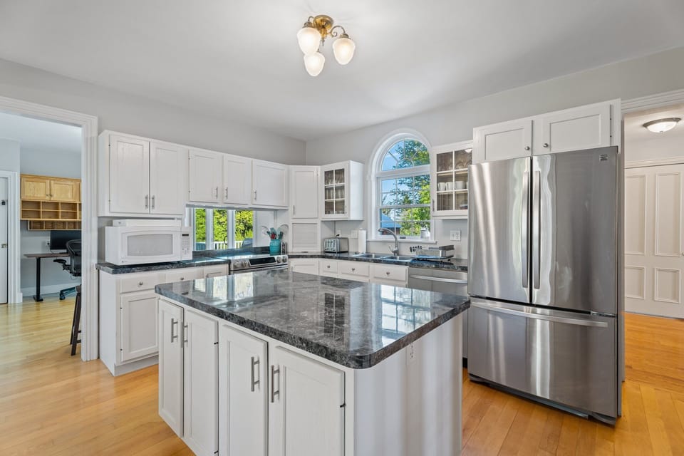 Open kitchen with full-size refrigerator, electric stove/oven and microwave