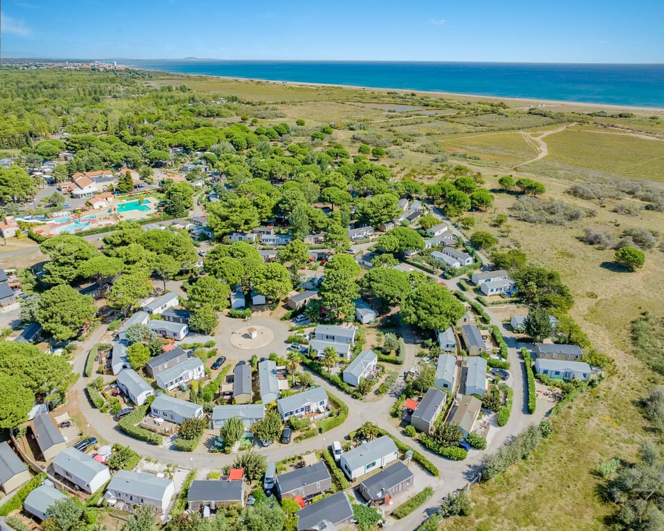 Aerial view of a tranquil camping community near the beach, nestled in nature for a serene stay.