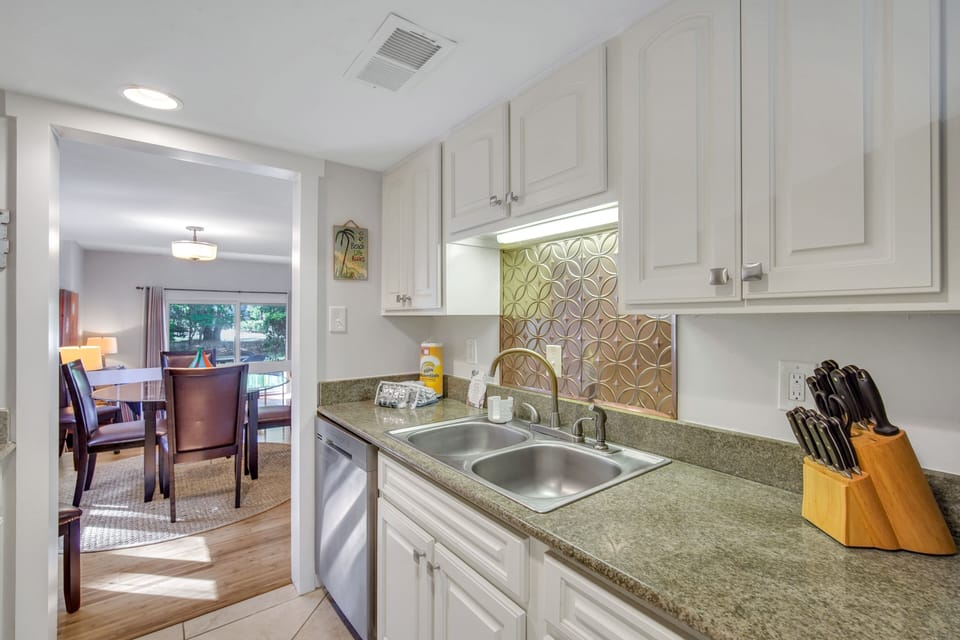 The kitchen features stainless steel appliances, pantry storage, and a coffee maker.
