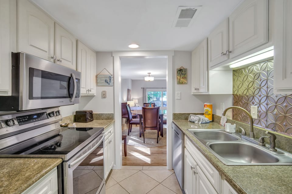 The kitchen features stainless steel appliances, pantry storage, and a coffee maker.