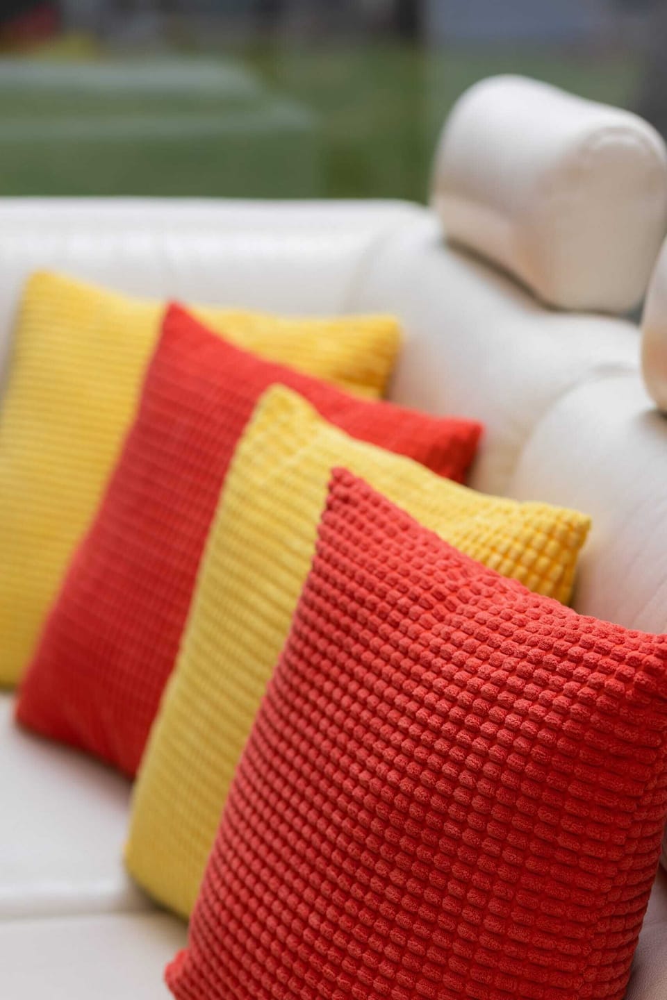 A close-up of vibrant red and yellow cushions, adding a pop of color to the decor.
