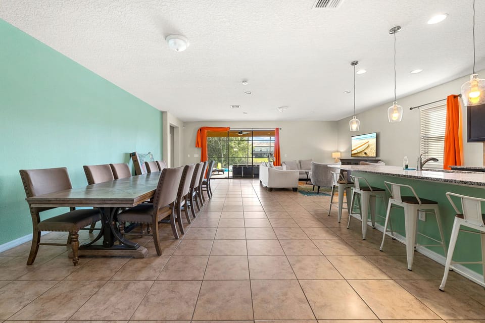 Open dining area w/ long table, bright light & an easy flow into the living space.