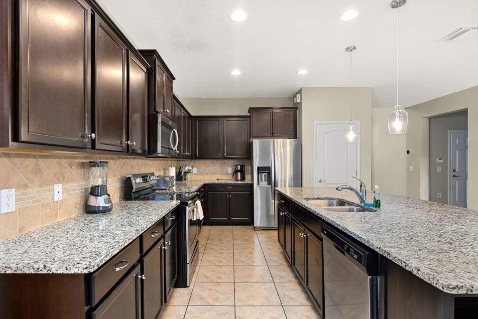 Modern kitchen layout w/ island, pendant lighting & generous counter space.
