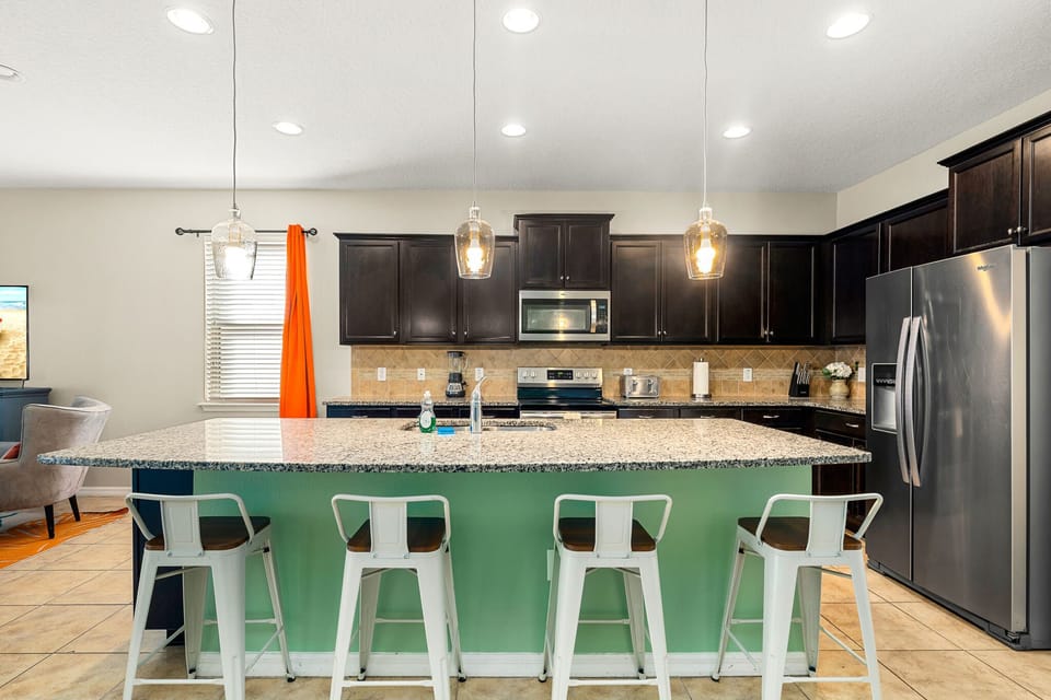 Stylish kitchen w/ island seating, modern lighting & plenty of prep space.