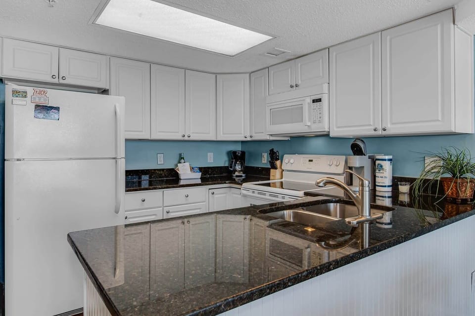 Prepare meals or sip your coffee in this stylish, fully equipped kitchen with modern appliances and ample counter space.