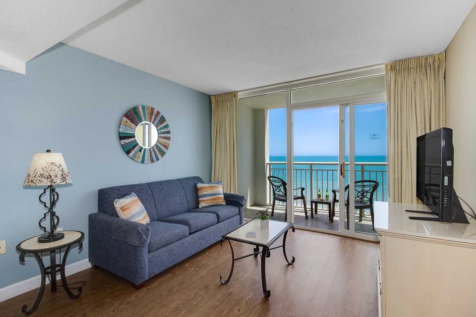 Soak in stunning ocean views from this cozy living space, complete with a comfy sofa, stylish décor, and private balcony access. Relax, recharge, and enjoy the serenity of beachside living.