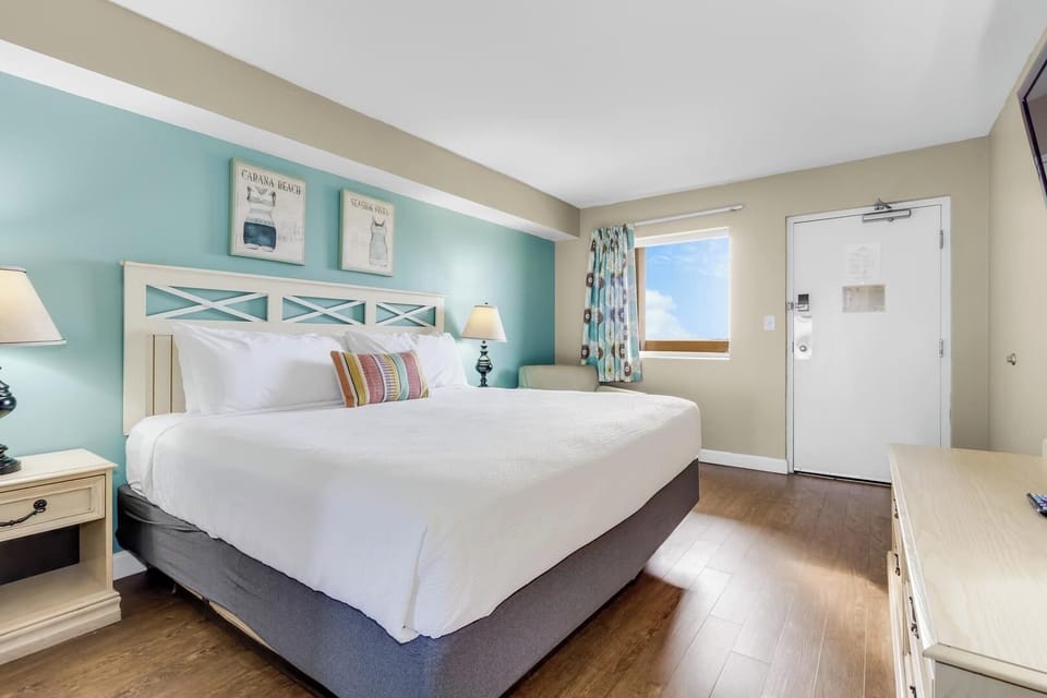 Bright and inviting bedroom featuring a plush king-size bed, soothing coastal colors, and natural light streaming through the window. A perfect retreat for a restful and rejuvenating stay!