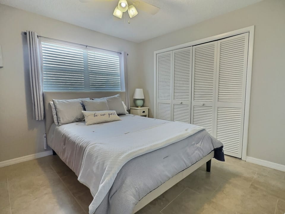 Second bedroom with double bed, ceiling light, and closet with bifold doors