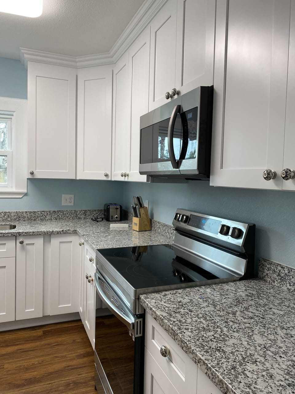Kitchen with electric range, convection oven with air fryer feature, microwave