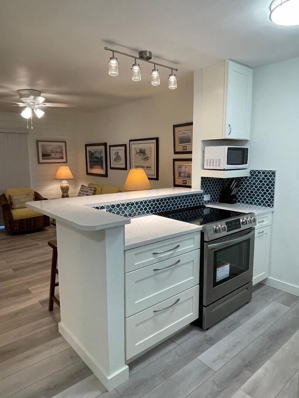 Your open-plan kitchen features modern appliances and stylish pendant lighting, flowing seamlessly into the cozy living area.