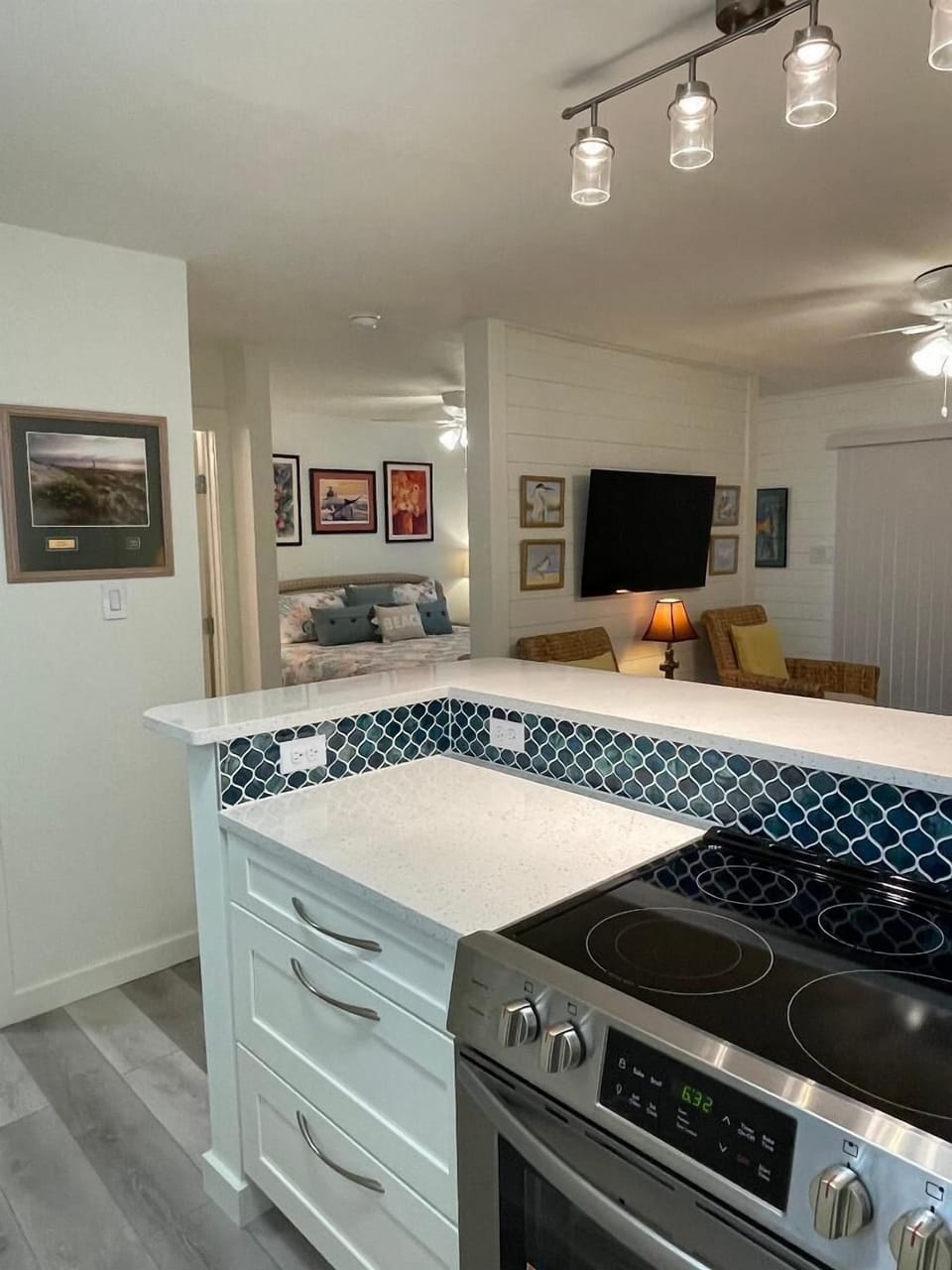 Your modern kitchen features granite countertops, a sleek glass cooktop, and stylish pendant lighting, perfect for preparing home-cooked meals.