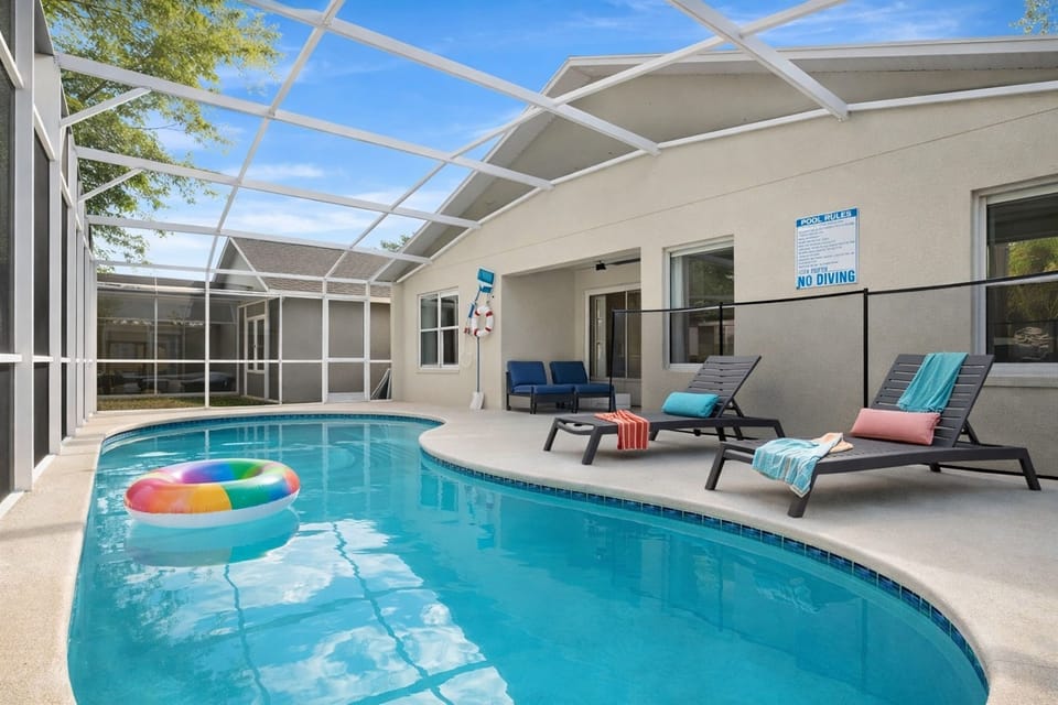 Private screened pool area with outdoor seating and a large movie screen for entertainment.