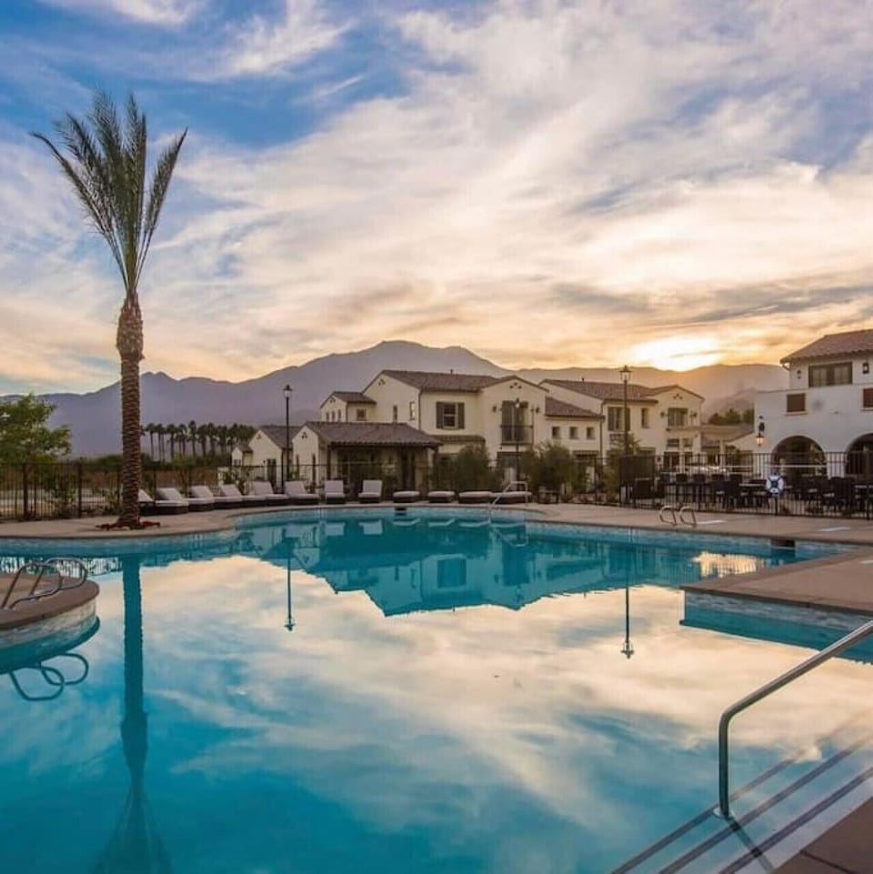 Resort-style pool glowing at sunset w/ mountain views in the background