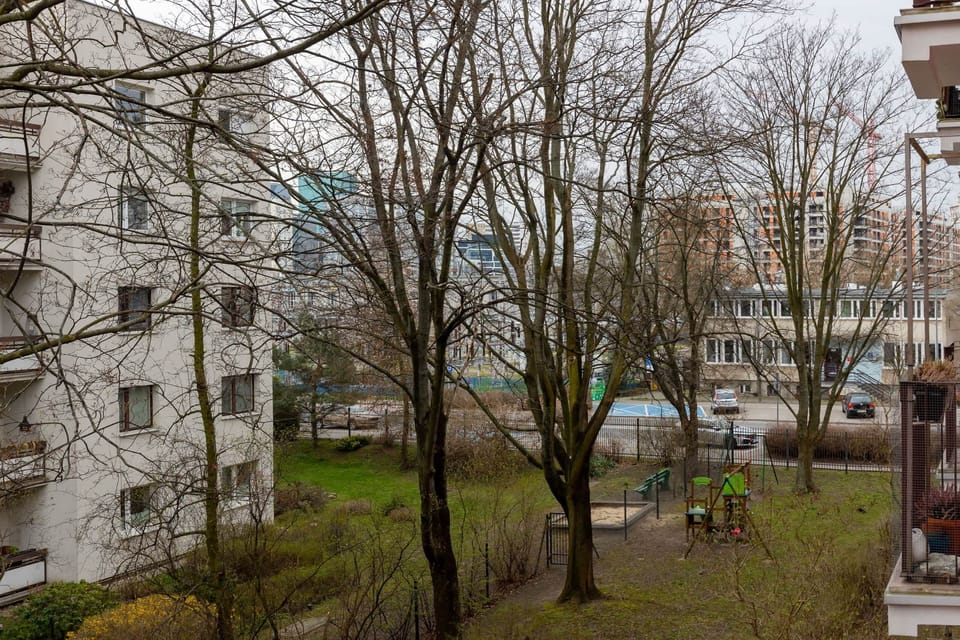A view of the residential building's exterior, surrounded by trees and greenery, emphasizing the peaceful location.