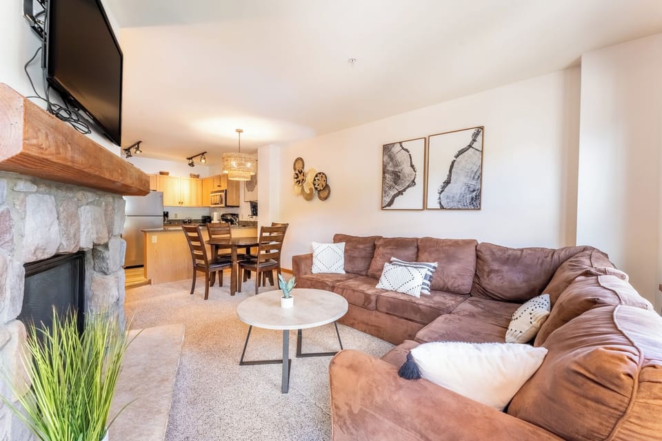 Sink into your plush leather sectional by the stone fireplace, where warm evenings unfold with mountain views and cozy conversations.