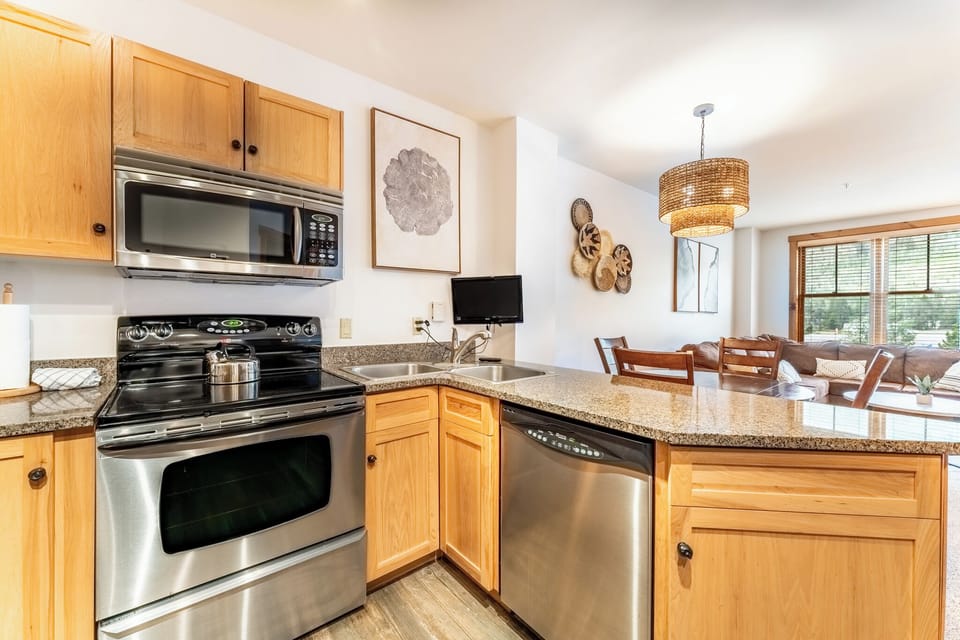 Your fully equipped kitchen features granite counters, stainless appliances, and warm wood cabinets perfect for preparing memorable meals together.