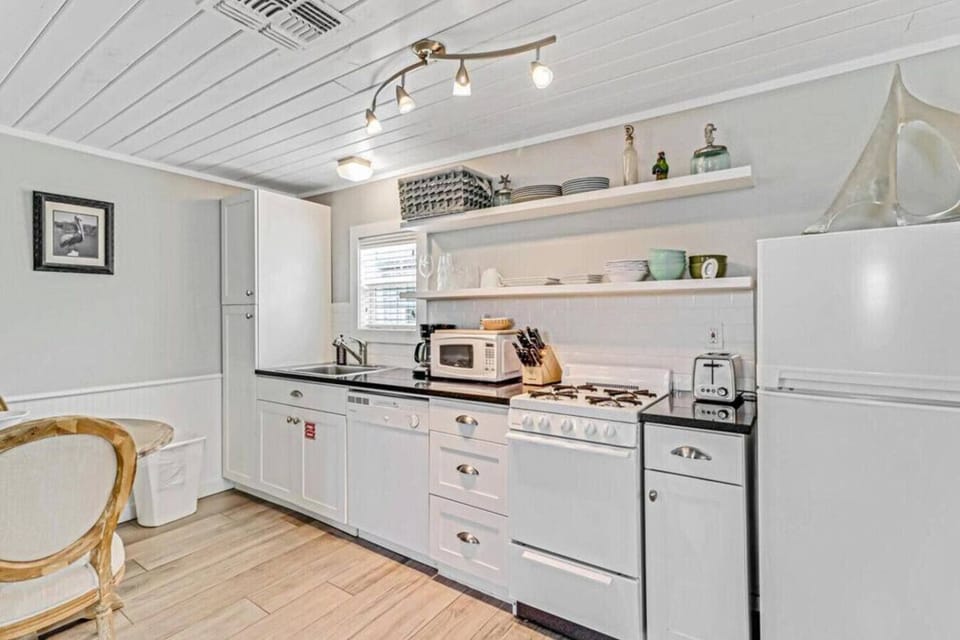 Fully equipped kitchen with modern appliances and open shelving.