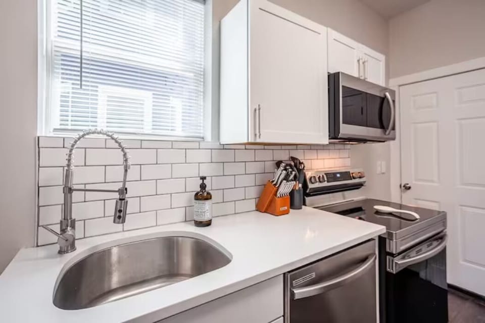 Stainless steel kitchen sink, dishwasher, oven/stove, microwave. 